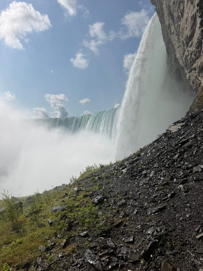 The falls from a viewing platform on the side. You can see the water falling with mist on the left and rocks in the foreground.
