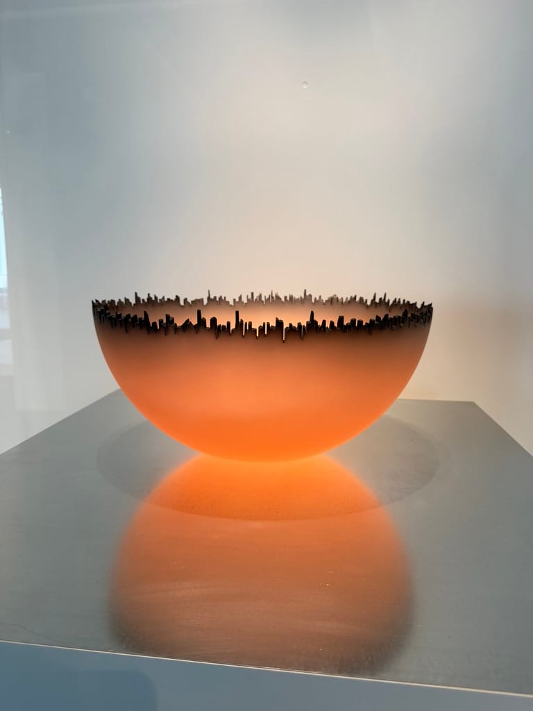 An orange bowl with brown edges shaped like a city skyline.